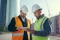 Two construction professionals reviewing plans on site.