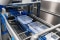 Plastic trays moving along a production line in a climate controlled manufacturing facility.