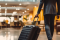 Hotel guest arriving in a lobby area with suitcase
