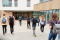 Busy campus walkway with students moving between buildings.