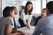 Diverse business team collaborating in a modern office, with a woman leading the discussion
